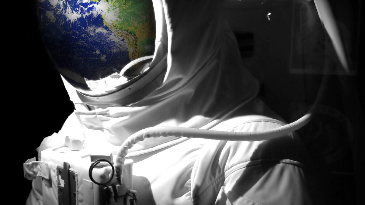 A complete astronaut space suit with a reflection of the earth reflecting in the helmet.  Selective color.  Earth photo courtesy of NASA.